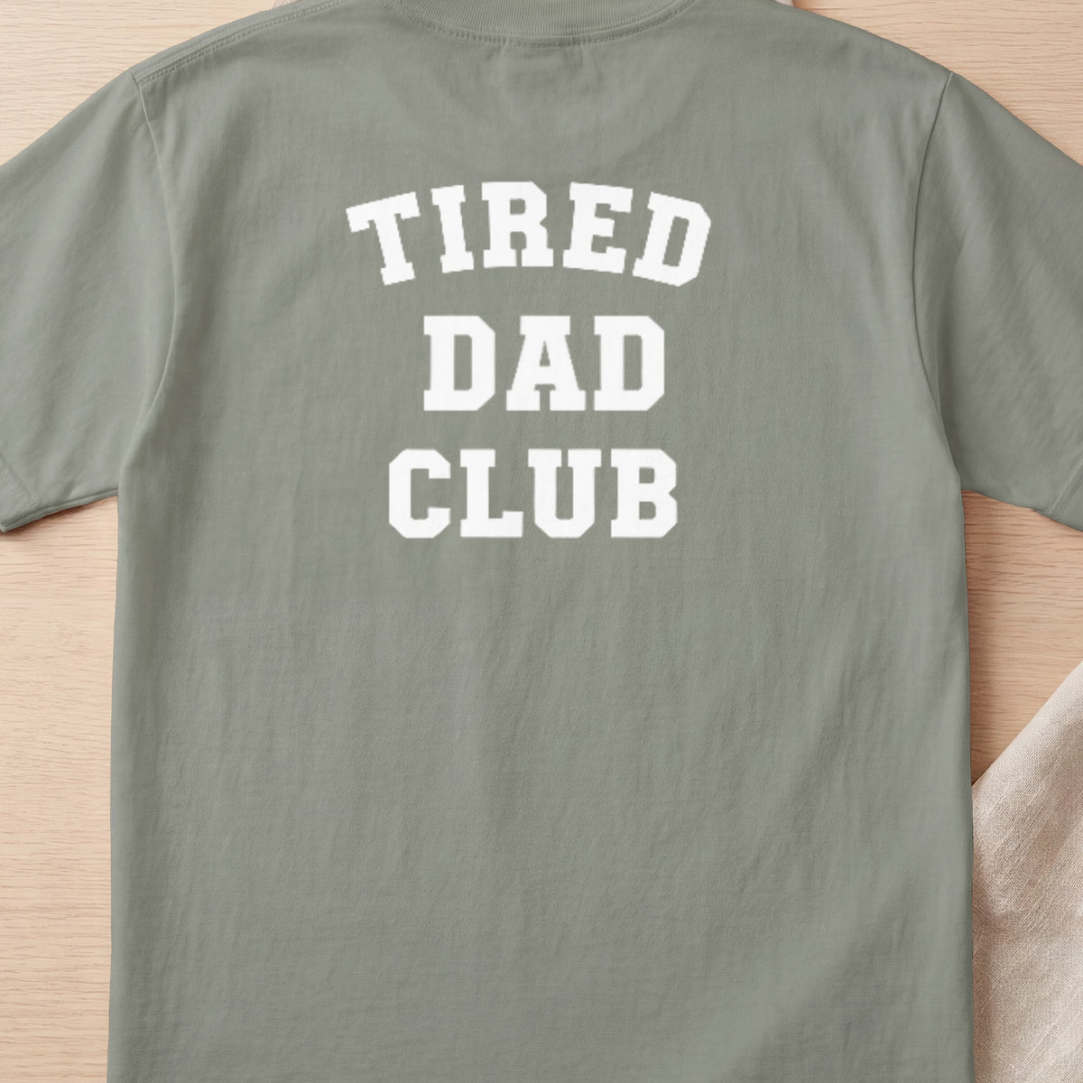 Green t-shirt with white block letters spelling "TIRED DAD CLUB".