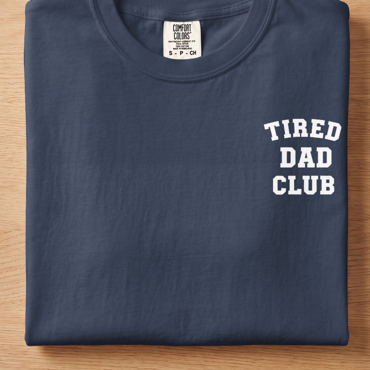 Navy t-shirt with "TIRED DAD CLUB" printed in white on the chest.