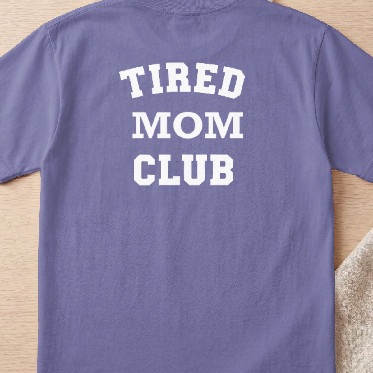 Purple t-shirt with white text "TIRED MOM CLUB"