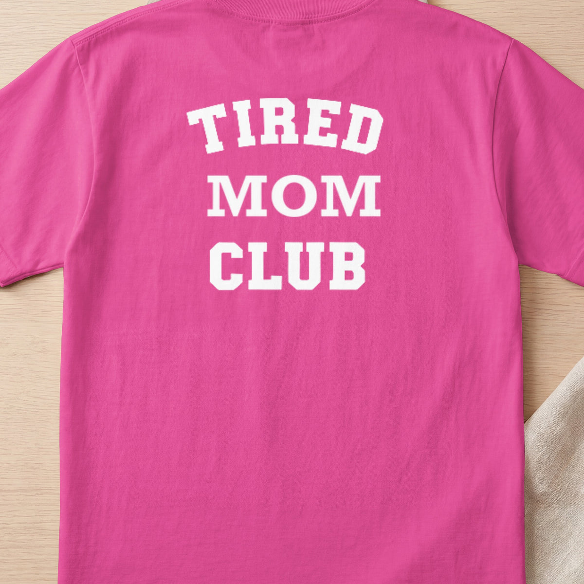 Pink t-shirt with white text "TIRED MOM CLUB"