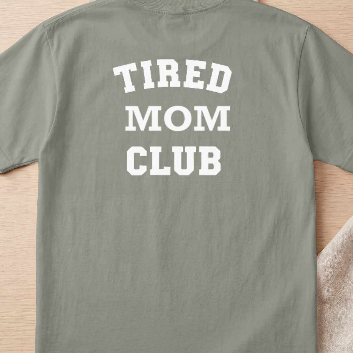 Tired Mom Club text on a light gray t-shirt.