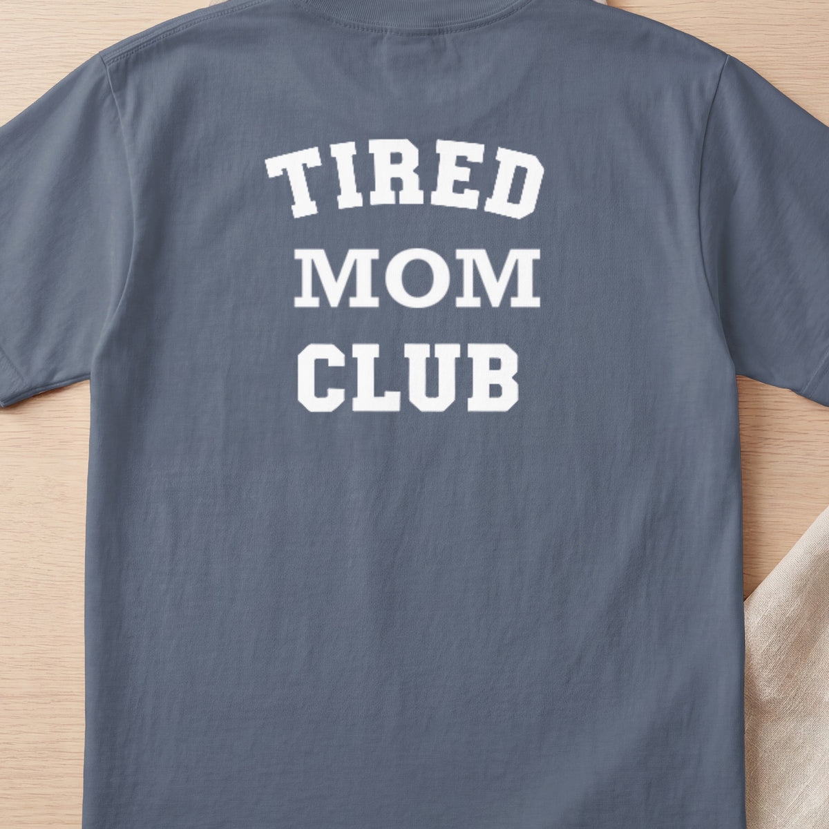 Gray t-shirt with white text "TIRED MOM CLUB" across the chest.