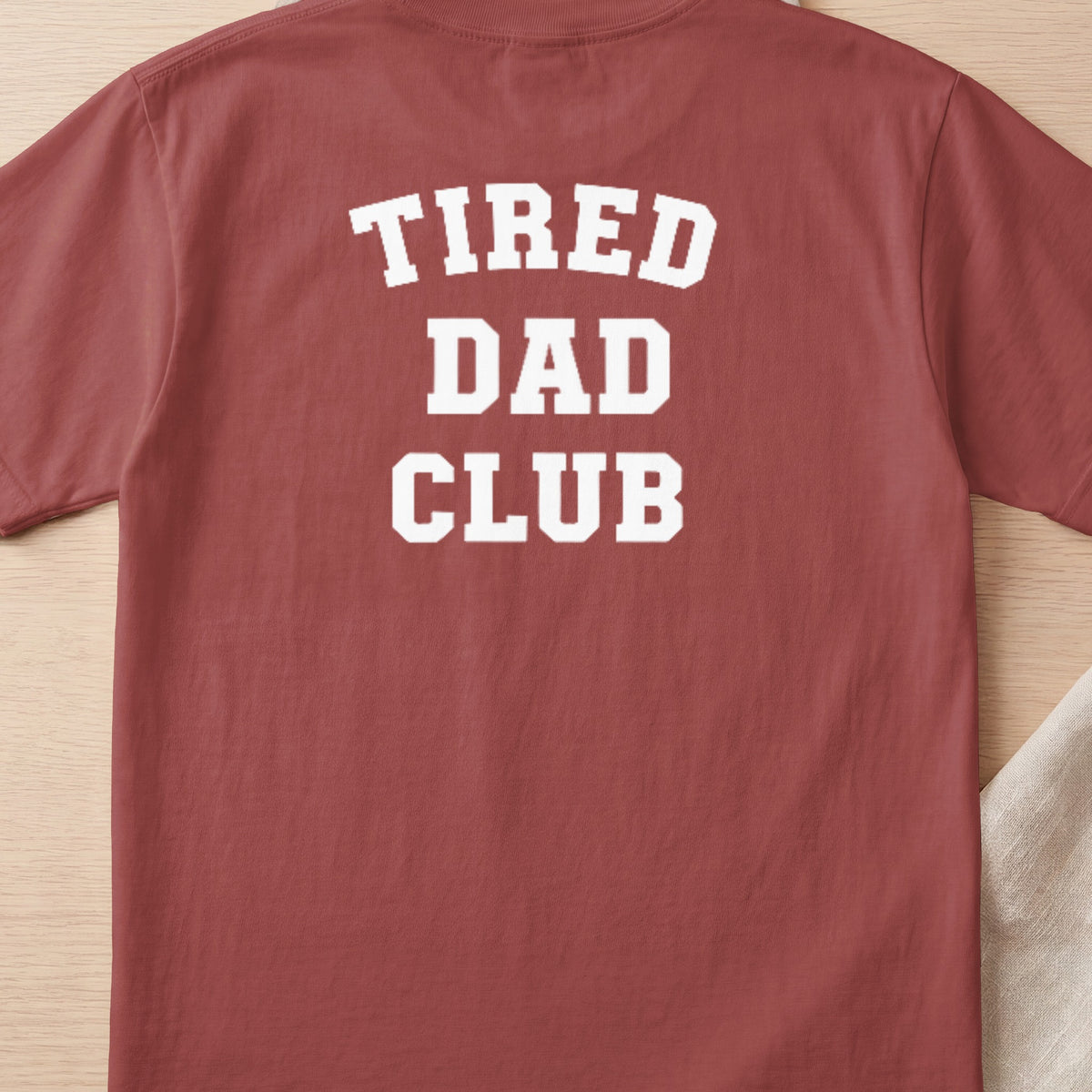 Red t-shirt with white text "TIRED DAD CLUB" on the back.