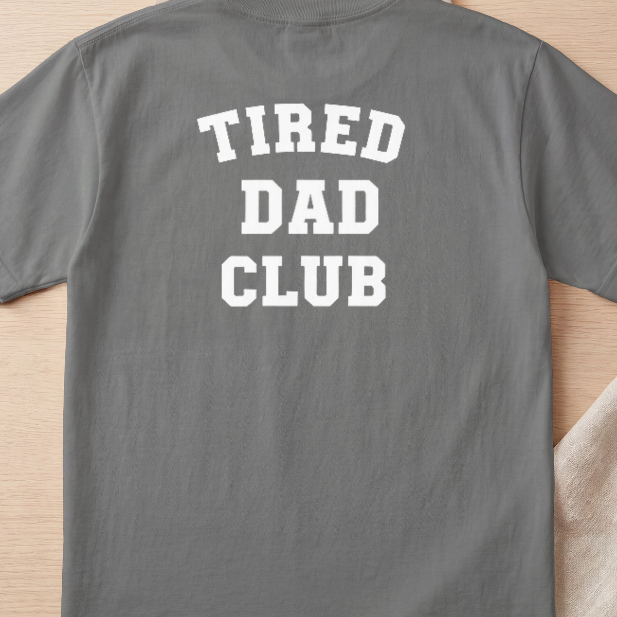 Grey t-shirt with white text "TIRED DAD CLUB" across the back.